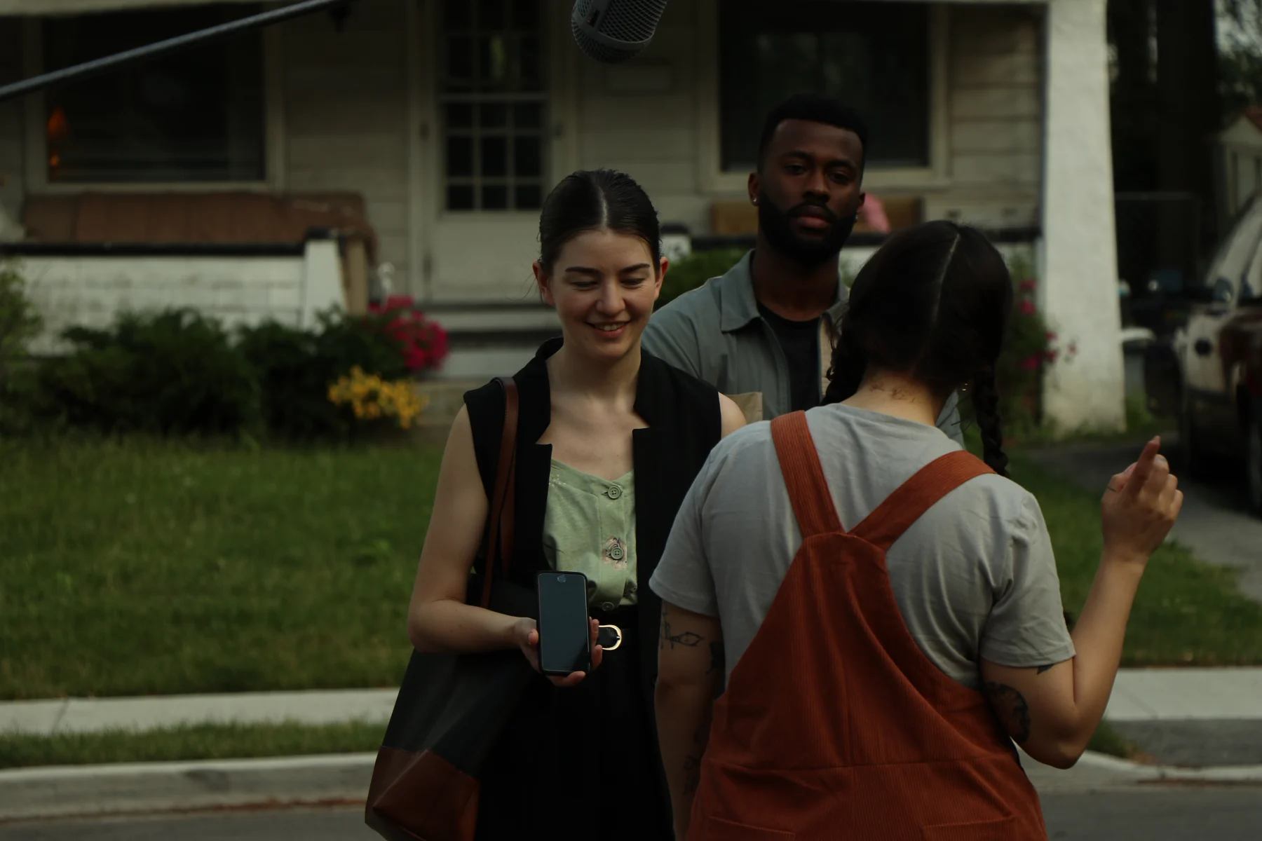 People gathered beneath a boom microphone on the exterior set of Threadbare.
